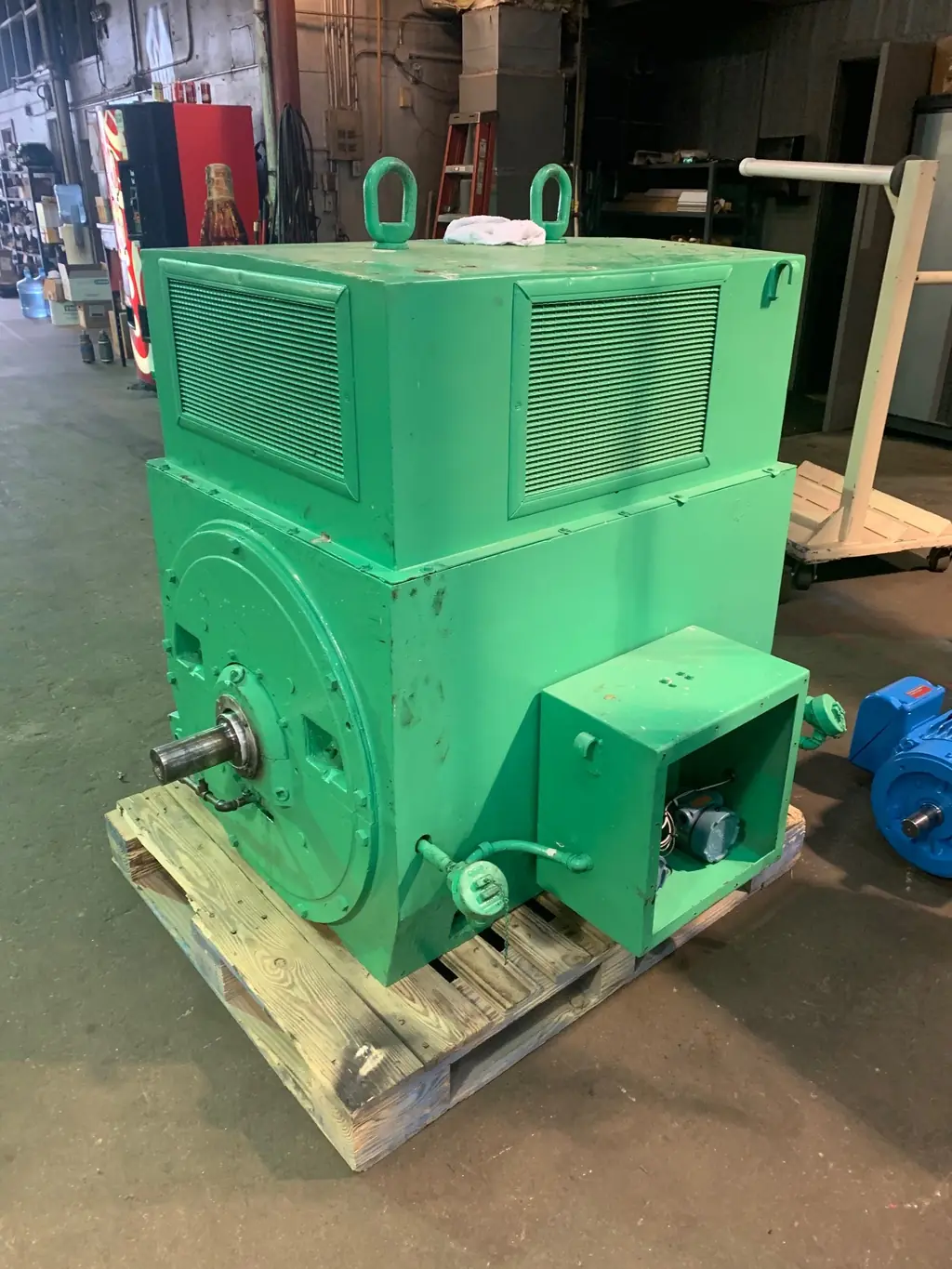A large rebuilt motor with a top-mounted air-to-air cooler, staged on a pallet in the shop.