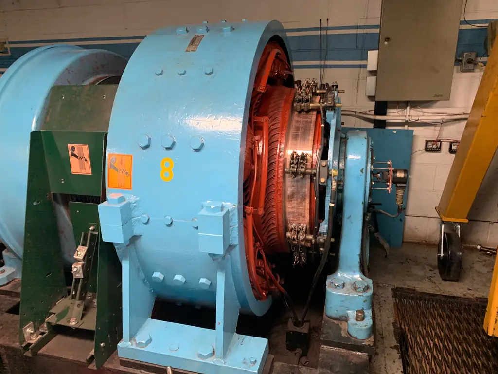 A blue synchronous motor with slip rings and brush rigging, back together in a customer plant room.